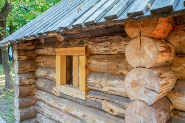 Geleneksel odunlardan yapılmış ahşap evler. Duvara bakan küçük bir pencere var.
