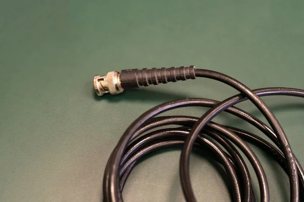 Kablo Sinyali Iletimi Için Yeşil Arkaplan Üzerindeki Siyah Kablo — Stok fotoğraf