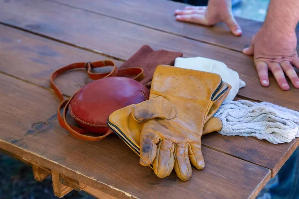 set of hunter accessories leather jar round and gloves folded on the table