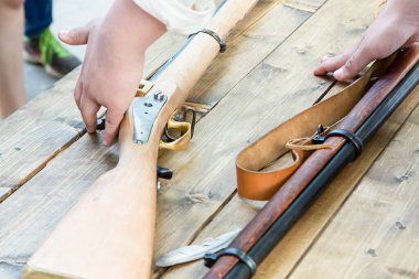 weapon flintlock light beige butt lies on a wooden table