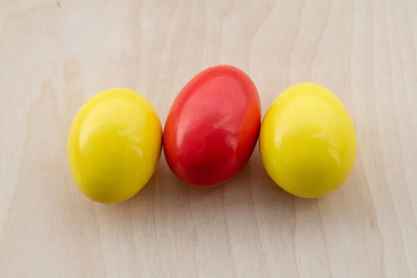 木製の背景に赤と黄色の卵がイースターのデザインをクローズアップ — ストック写真