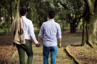 Beautiful gay couple in the park clipart
