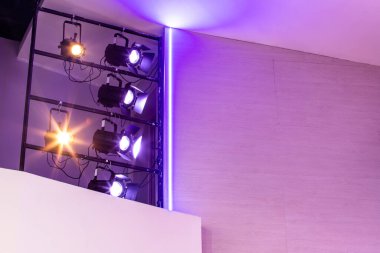 Tiyatro sahnesinin tavanında çok renkli ışıklandırma ekipmanları var. Sahne ışıklandırması. Sirkte beyaz projektörler. Sahne ışıklarının çok renkli ışıkları..