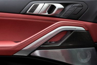 Arabanın kapısında krom saplı kapı kontrol panelini kapat. Yeni arabadaki siyah ve kırmızı gerçek deri. Koltuk ayarlı kol istirahatı ve bagaj kontrol paneli açık