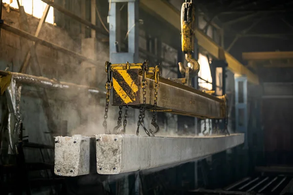 The crane moves a reinforced concrete product with holes