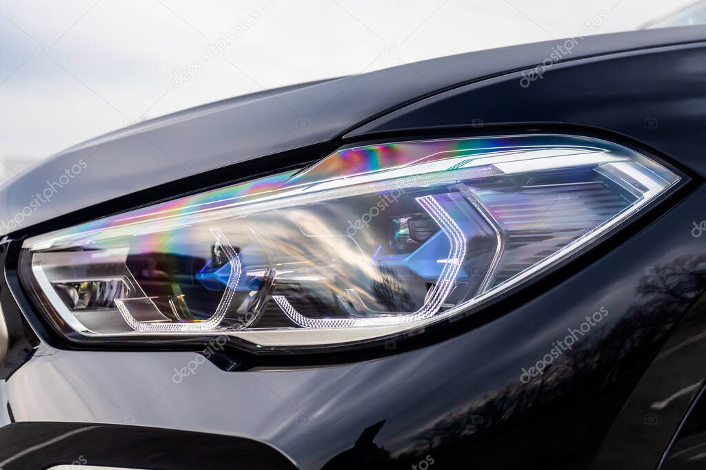 Glowing Headlight of a modern car close-up.  Car xenon lamp headlight. Exterior of a exprnsive car