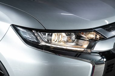 Novosibirsk, Rusya 26 Ekim 2020: Mitsubishi Outlander, arabanın ön tarafı. Gümüş araba farları. 