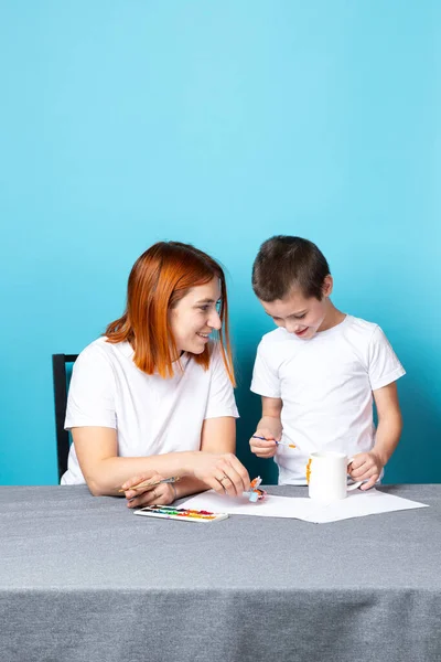 Μαμά Και Γιος Λευκά Μπλουζάκια Ασχολούνται Σχέδιο Ακουαρέλες Μπλε Φόντο — Φωτογραφία Αρχείου