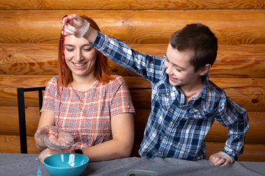 Anne ve oğlu kimyasal deneyler yapıyorlar. Evdeki masada çok renkli polimer solucanlar yapıyorlar. Anaokulunda kimyanın temellerini öğretiyorum.