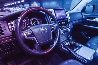 Novosibirsk, Rusya 26 Mart 2021: Toyota Land Cruiser, gösterge paneli, direksiyon simidi, hız göstergesi ve taktik ölçeri olan prestij arabası. Pembe neon ışığın altında siyah deri iç döşeme 