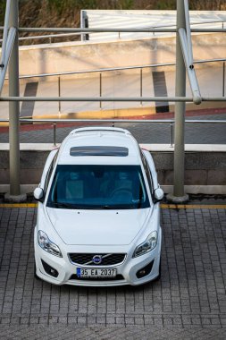 Antalya, Türkiye 12 Nisan 2021: Sıcak bir yaz gününde caddeye park etmiş beyaz Volvo c30 bir binanın arka planına karşı 