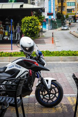 Alanya, Türkiye 12 Nisan 2021: Kentin arka planında kasklı motosiklet polisine yakın çekim 