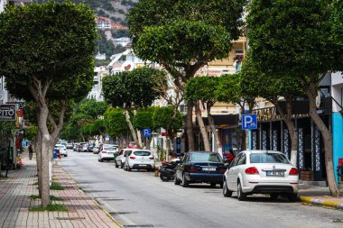 Alanya, Türkiye 10 Nisan 2021: Aynı tipte çok katlı evler, park edilmiş arabalar, dükkanlar 