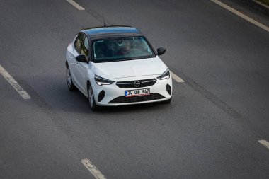 Alanya, Türkiye 13 Nisan 2021: Beyaz Opel Corsa caddede hızla ilerliyor, yukarıdan görünüyor 