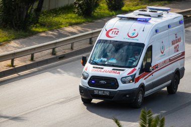 Alanya, Türkiye 12 Nisan 2021: Ford beyaz ambulans caddede hızla ilerliyor, yukarıdan görünüyor  