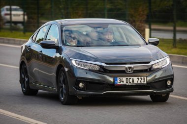 Alanya, Türkiye 13 Nisan 2021: Siyah Honda Civiç sıcak bir yaz gününde palmiyelerin arkasına doğru hızla sürüyor  