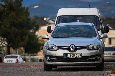 Alanya, Türkiye 13 Nisan 2021: Gümüş Renault Fluence sıcak bir yaz gününde bir sokak arkaplanına, palmiyelere karşı sokağa park edildi 