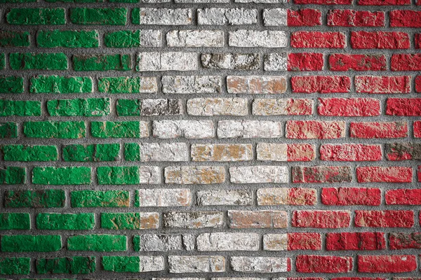 National flag of Italy depicting in paint colors on an old brick wall. Flag  banner on brick wall background.