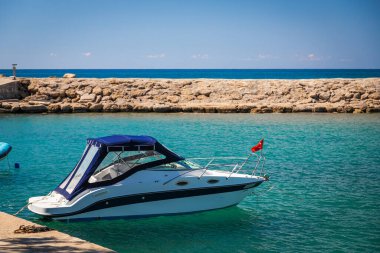 Türkiye 'nin antik kenti Side, Türkiye' nin kıyı şeridinde demirli Türk bayrağıyla beyaz bir yat.