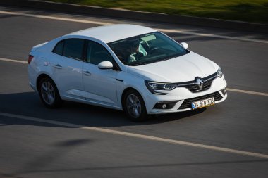 Alanya, Türkiye 17 Nisan 2021: Gümüş Renault Megane sıcak bir yaz gününde palmiyelerin arkasına doğru hızla sürüyor  