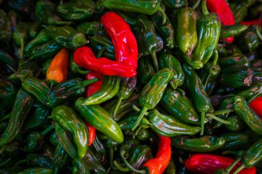 Arka plan için yakın plan yeşil ve kırmızı sebze, biber dokusu. Yeşil biberler doğal bir şekil alırlar. Taze çiğ sebzeler