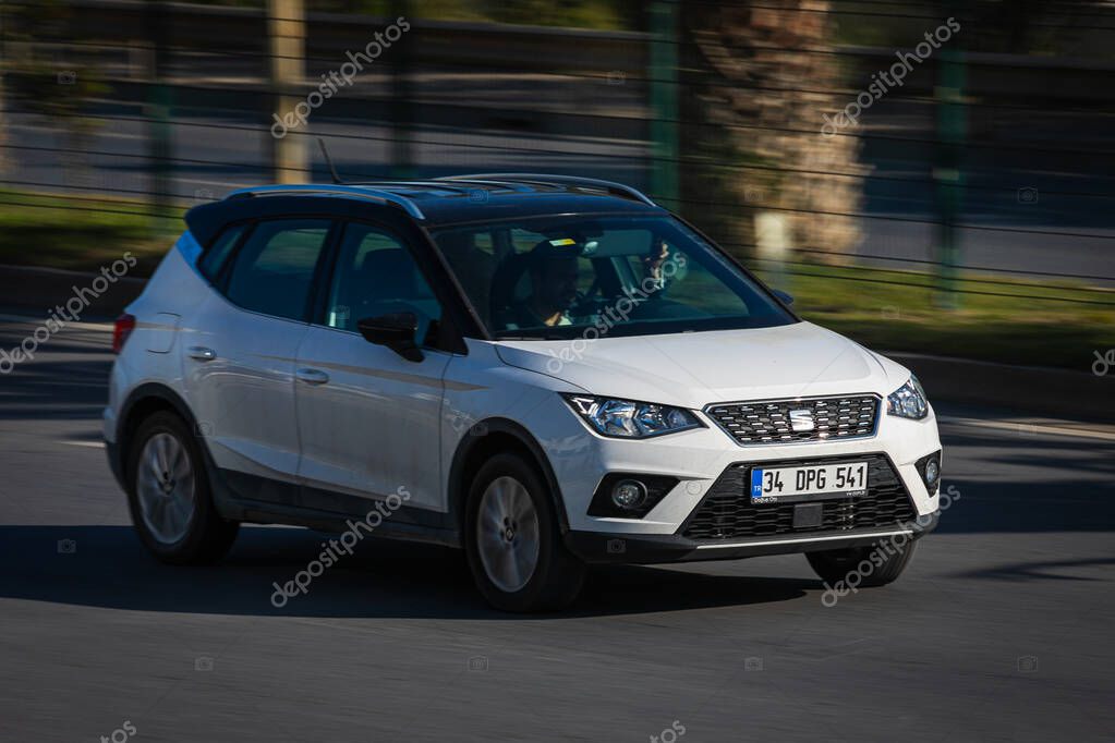 Alanya, Turkey   April 17  2021:    white Seat Arona   is driving fast on the street on a warm summer day against the backdrop of a  palms