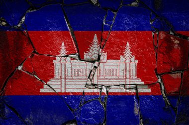 Kamboçya 'nın ulusal bayrağı eski bir taş duvarda boya renkleriyle tasvir ediliyor. Kırık arka planda bayrak pankartı.