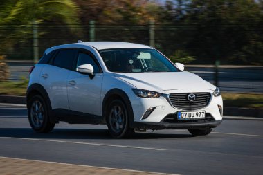 Alanya, Türkiye 17 Nisan 2021: Gümüş rengi Skoda Fabia sıcak bir yaz gününde palmiyelerin arka planına doğru hızla sürüyor  