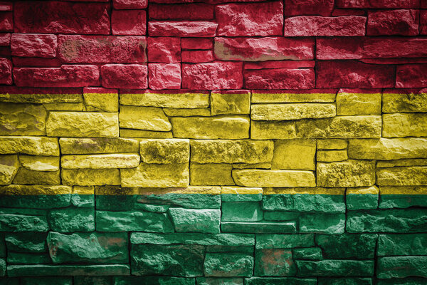 National flag of Bolivia on stone  wall background.The concept of national pride and symbol of the country. Flag  banner on  stone texture background.