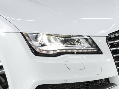 Novosibirsk, Rusya - 16 Mayıs 2021: Audi A7, modern popüler bir arabanın yakın çekimi. Işıktan parlayan parlak cam araba farları.
