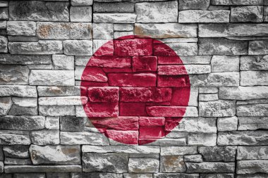 Japonya 'nın ulusal bayrağı arka planda taştan duvarda. Ulusal gurur kavramı ve ülkenin sembolü. Taş dokusu arka planında bayrak pankartı.
