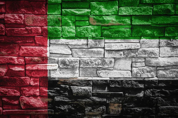 石の壁の背景にアラブ首長国連邦の国旗 国の国民の誇りとシンボルの概念 石の質感の背景に旗 — ストック写真