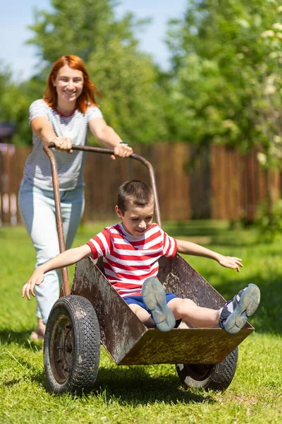 Joyeux Garçon Joyeux Amuser Dans Une Brouette Poussant Maman Dans — Photo