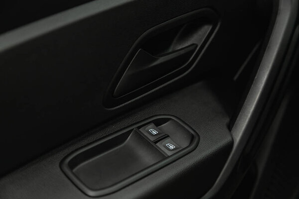Novosibirsk, Russia - June 29, 2021: Renault Duster, Car door interior armrest with window control panel, door lock button. 