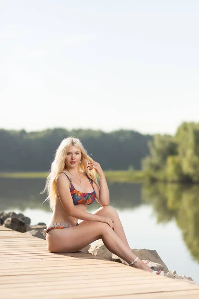 户外紧贴着身穿泳衣的年轻漂亮女子的画像 她的姿势紧靠着湖面 夏天散步的概念 — 图库照片