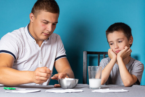 Папа и сын проводят химические эксперименты, наблюдая изменение цвета хамелеона в результате химической реакции йода и крахмала дома. Обучение основам химии в дошкольном возрасте