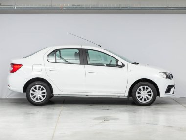 Novosibirsk, Rusya - 20 Ağustos 2021: beyaz Renault Logan, yan görüş. Otoparktaki popüler araba.