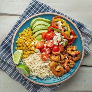 Meksika 'dan esinlenilmiş, kahverengi pirinç, renkli kavrulmuş sebzeler, sulu karides ve kremalı fetanın yer aldığı bir karides kasesi, besleyici bir öğle yemeği ya da akşam yemeği seçeneği için ideal..