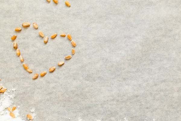 Baking background with heart from wheat grain — Zdjęcie stockowe