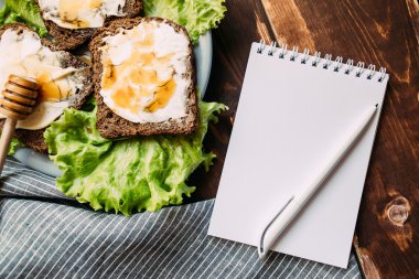 Defter bir kalem sandviç yanındaki masada ile