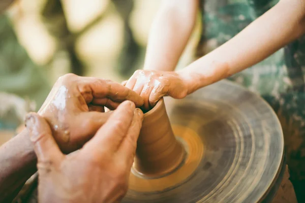 Potter onderwijst aan het beeldhouwen van een klei pot — Stockfoto