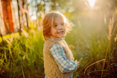 Günbatımı yeşil bir alanda sevimli gülümseyen kız 