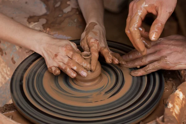 Potter ensina a esculpir em panela de barro em uma roda de cerâmica girando — Fotografia de Stock