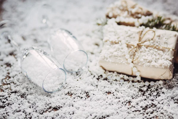 Kerstmis, Nieuwjaar achtergrond met wijnglazen en te presenteren op sneeuw — Stockfoto