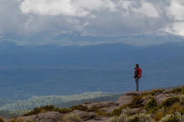 男子徒步旅行者 背着背包站在悬崖边上 身后是美丽的自然景观 — 图库照片