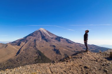 A beautiful shot of a male standing in Pico de Orizaba Volcano in Mexico clipart