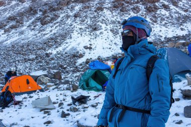 Pico de Orizaba 'daki çadırların yanındaki yürüyüşçü karla kaplı.