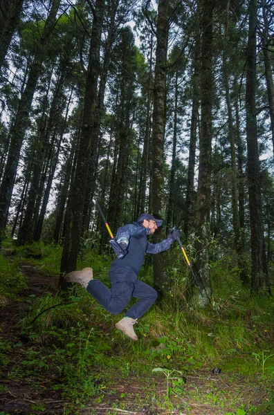 Hombre Saltando Bosque Con Bastones —  Fotos de Stock