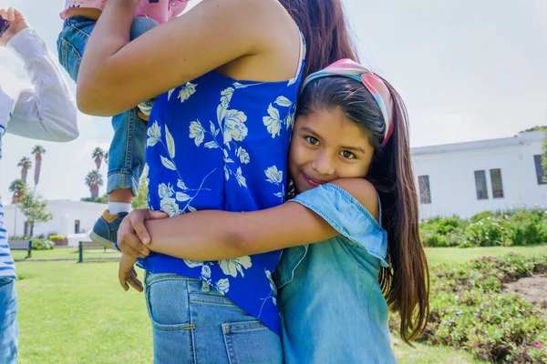 Roztomilá Hezká Hispánská Dívka Objímající Svou Matku Jejích Zad — Stock fotografie