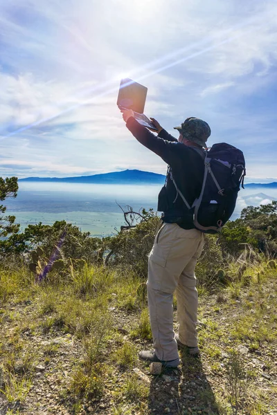 背包客带着笔记本电脑翻山越岭 — 图库照片